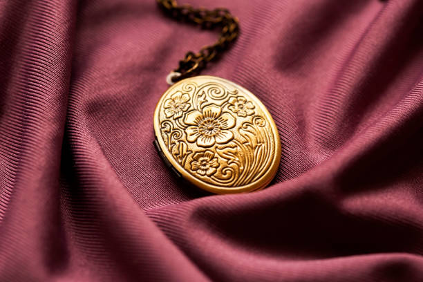 fofo vintage medalhão de bronze da vovó em um fundo de tecido roxo - locket - fotografias e filmes do acervo