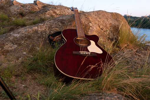 acoustic guitar on the rock. guitar at the sunset, music background concept. acoustic instrument