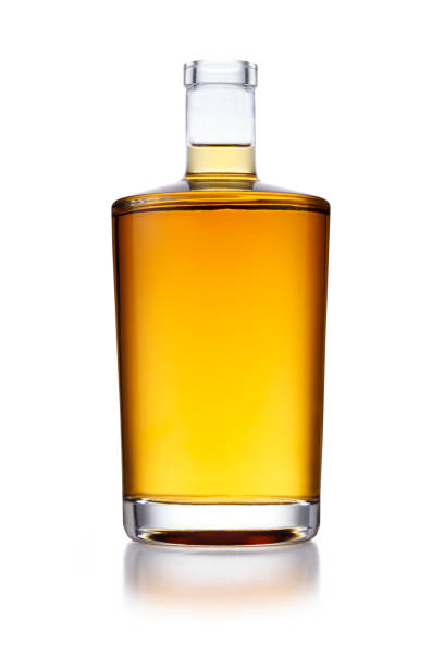 a full angular shaped bottle of golden whisky, with no label or branding, isolated on white - brandy bottle alcohol studio shot imagens e fotografias de stock