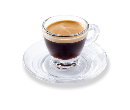 Angled view of a modern glass expresso cup and saucer full of smooth expresso coffee, isolated on white with a slight drop shadow
