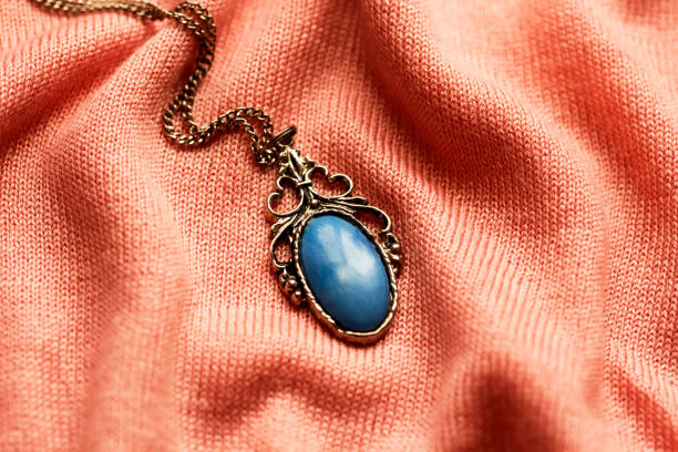 istock lovely vintage medallion with blue gemstone on a pink fabric texture 1252383134