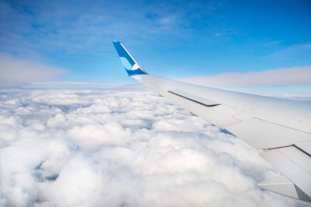 istock Aircraft wing in the blue sky with clouds 1252385386