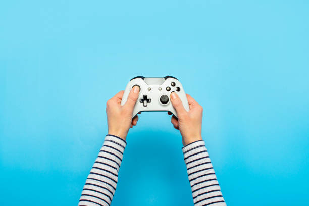 istock Hands holding a gamepad on a blue background. Banner. Concept games, video games 1252386803