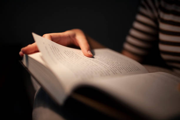 istock Close-up of hands holding a book in low light 1252387098
