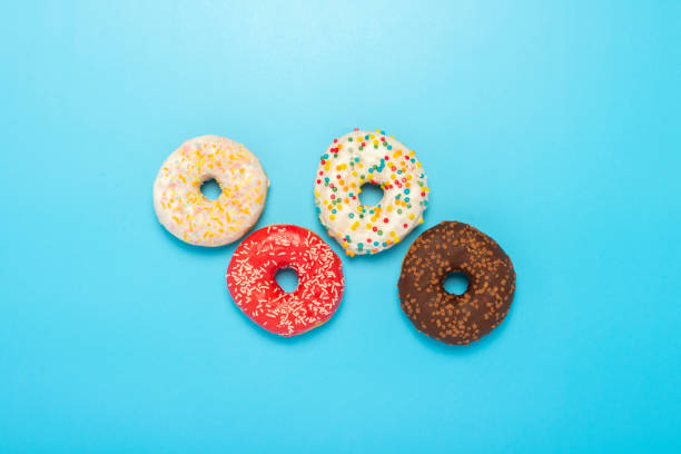 istock Donuts of different types on a blue background. Concept of sweets, bakery,. Banner. Flat lay, top view 1252389501