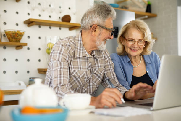 istock Senior couple checking their bills using laptop in the kitchen 1252391269