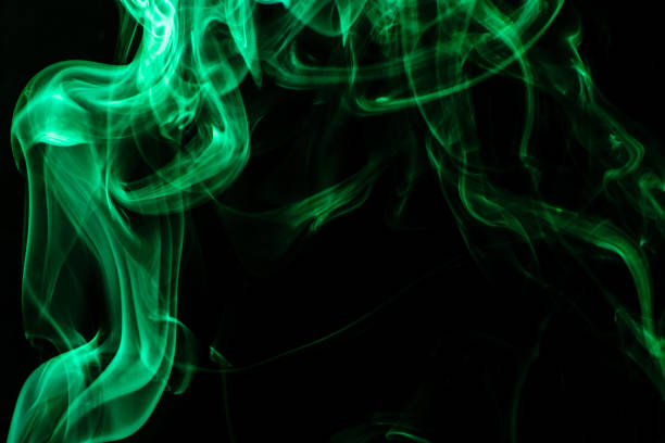 istock Green colored puffed smoke in a dark background 1252392303