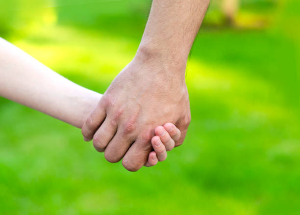 istock Child holding father hand outdoor 1252392316