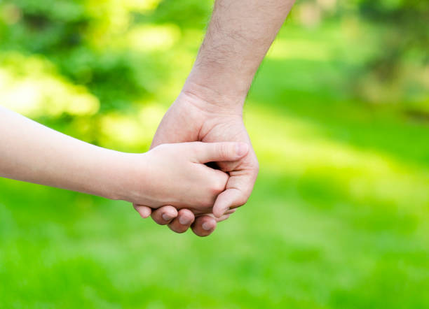 istock Child holding father hand outdoor 1252392346