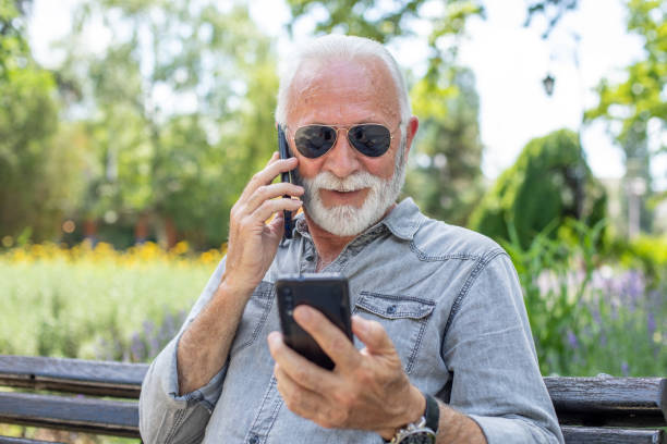 istock Old man compare two smartphones 1252394268