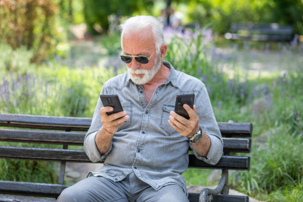 istock Old man compare two smartphones 1252394834
