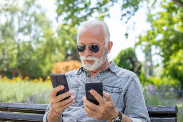 istock Old man compare two smartphones 1252395476
