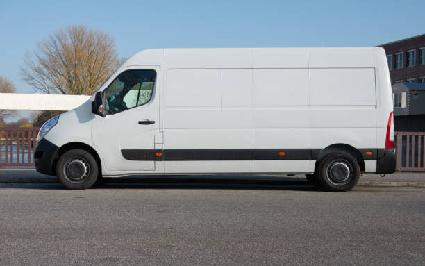 белый фургон доставки припаркован на улице в торговом районе - van white truck mini van стоковые фото и изображения