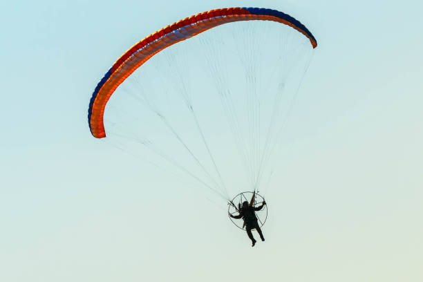 istock Colorful powered paraglider against blue sky 1252397649