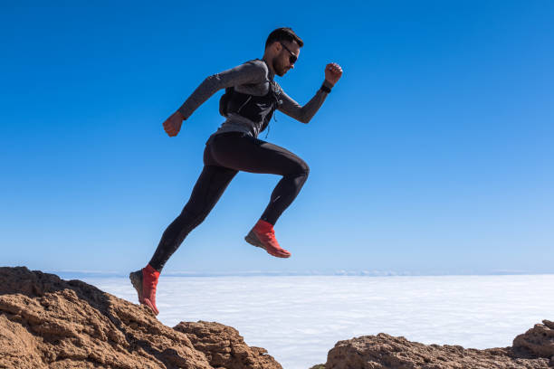 istock Man jump through the gap over the sky 1252400533