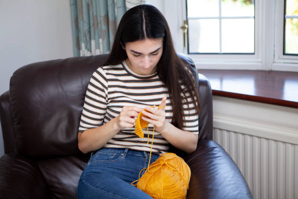 istock Young woman crocheting with yellow wool 1252402011