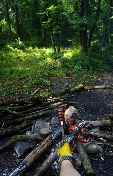 Photo of Cooking banger (sujuk) on campfire in forest, Camping in nature