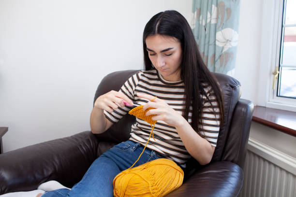 istock Young woman crocheting with yellow wool 1252403147