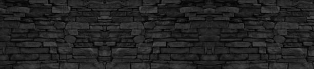 istock panorama black brick wall of dark stone texture and background 1252403173