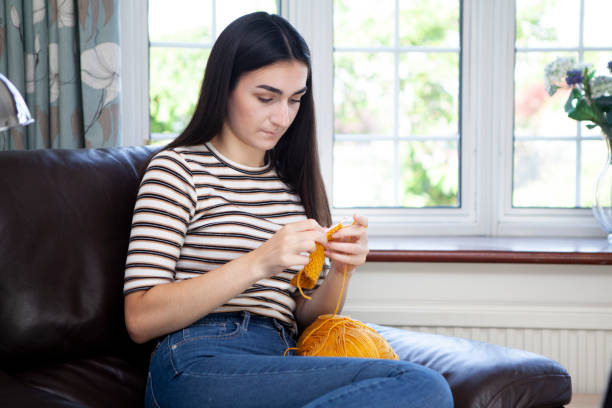 istock Young woman crocheting with yellow wool 1252403393