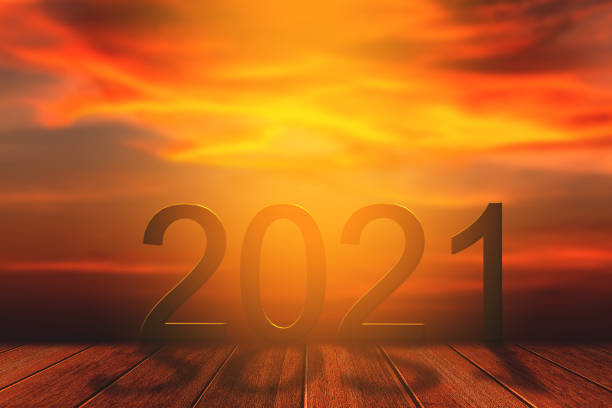 istock 2021 text on sand beach over blurred sunset sky background for new year concept. 1252404400