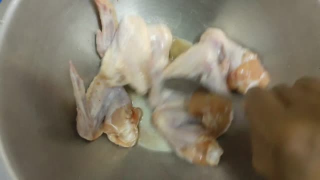Footage of Hand Use Spoon Cooking Chicken Wing