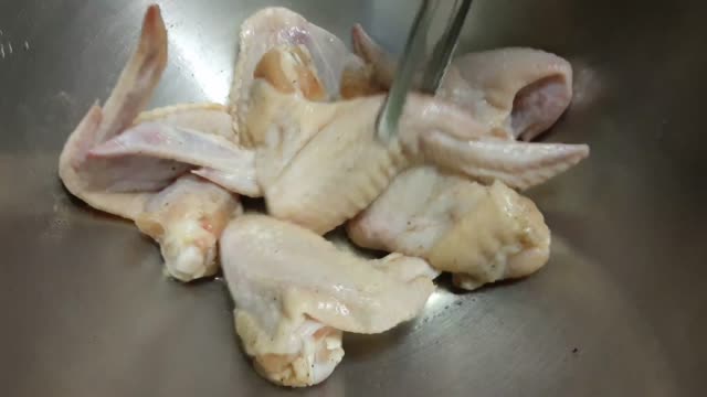 Footage of Hand Use Tongs Cooking Chicken Wing