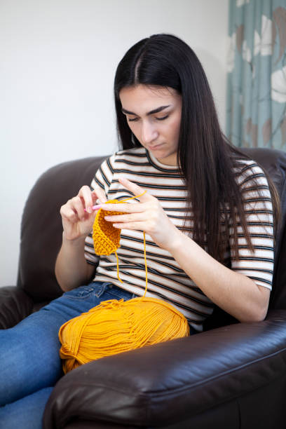 istock Young woman crocheting with yellow wool 1252405046