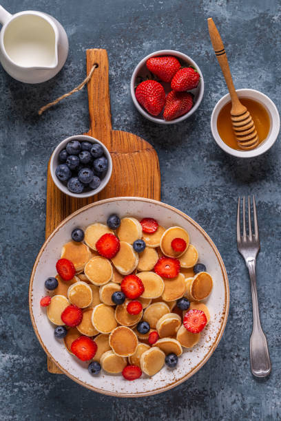 istock Tiny pancakes with strawberries and blueberries for breakfast. Top view. 1252407554