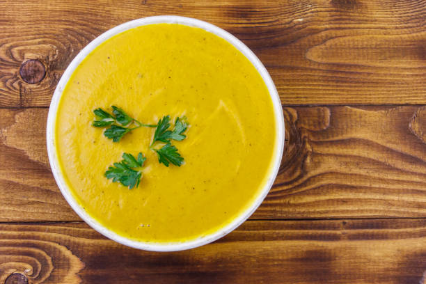istock Pumpkin soup on a wooden table. Top view 1252407687