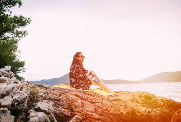 istock Woman Reading Book at Sunset 1252408740