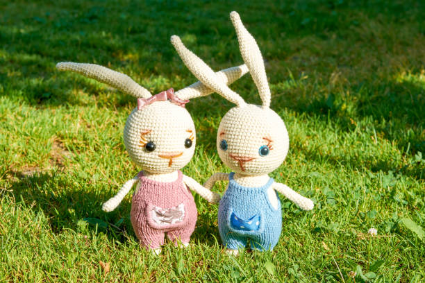 istock Two toy Easter rabbits on the green grass on a summer day. 1252408881