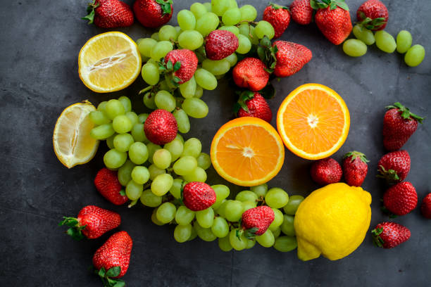 istock Various fruits and berries on dakr background 1252414312