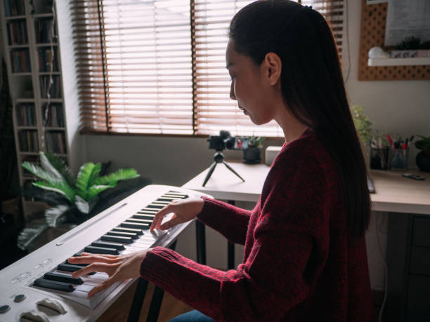 istock Young Woman Giving Piano lesson On Internet With Video Tutorial At Home. 1252414372