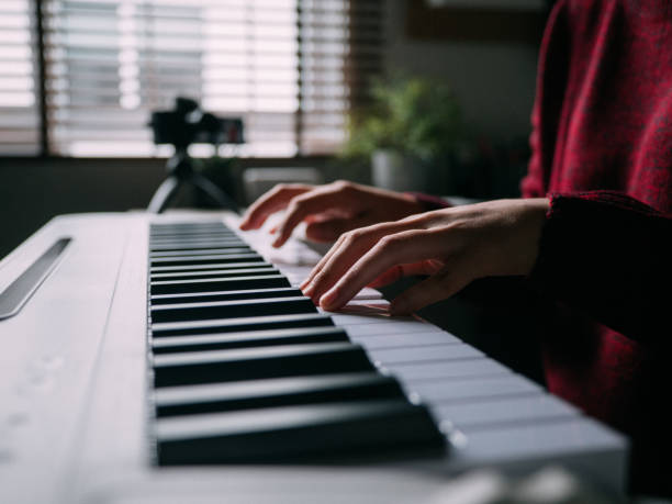 istock Millennial woman learning to playing keyboard piano at home 1252414404