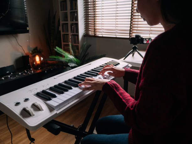 istock Young Woman Giving Piano lesson On Internet With Video Tutorial At Home. 1252414409