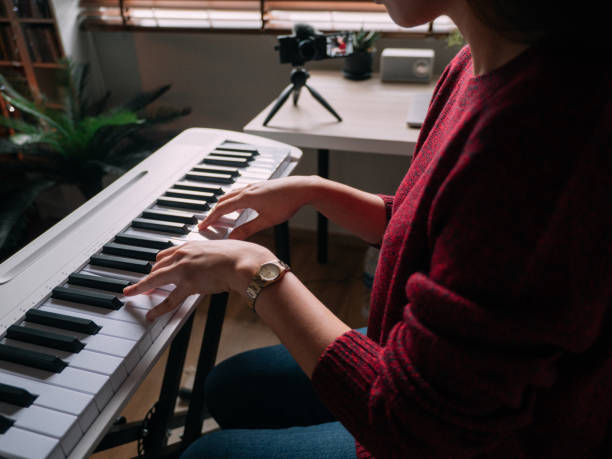 istock Young Woman Giving Piano lesson On Internet With Video Tutorial At Home. 1252414417