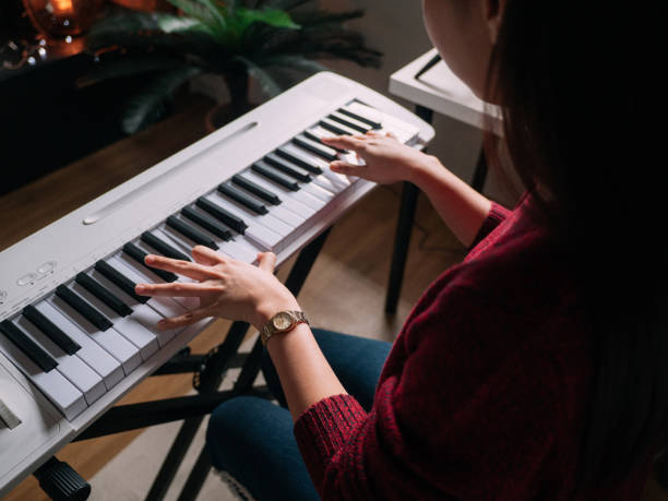 istock Millennial woman learning to playing keyboard piano at home 1252414933