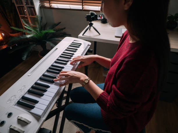 istock Home Alone Keyboard Piano Hobby Young woman Practicing Piano With Smartphone 1252414941