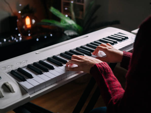istock Home Alone Keyboard Piano Hobby Young woman Practicing Piano With Smartphone 1252414942