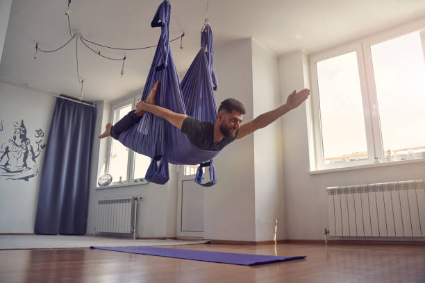 istock Bearded athletic man doing antigravity yoga exercise 1252417375
