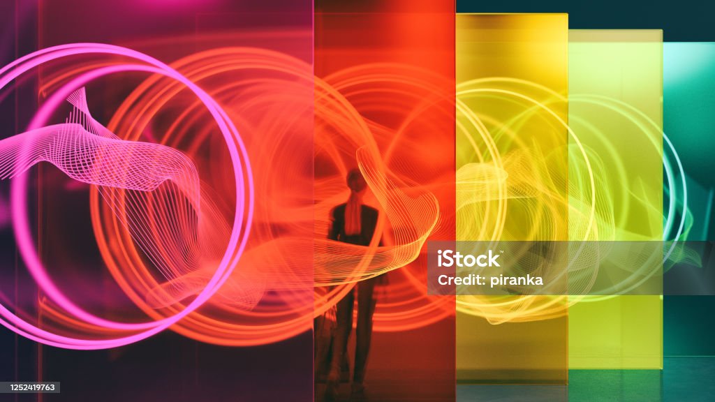 Illuminated glass wall A person standing among glass walls illuminated by glowing rings. All objects in the scene are 3D Technology Stock Photo