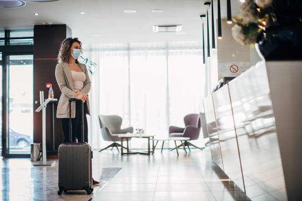 istock Businesswoman with protective face mask at a hotel reception 1252420105