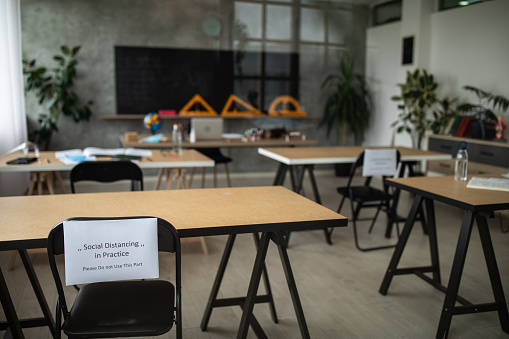 Empty classroom with social distancing information on chairs
