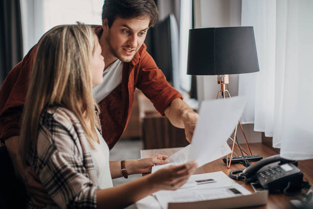 istock Beautiful young couple reading a guide in a hotel room 1252420743