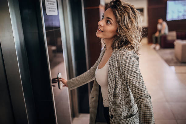 istock Young businesswoman calling the elevator in hotel lobby 1252421742