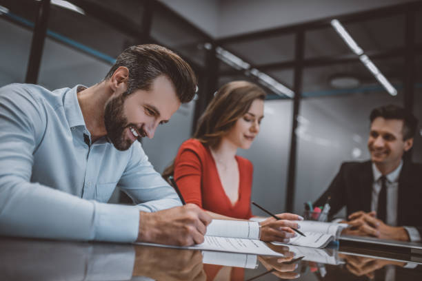 istock Smiling man signing a document together with his wife 1252438027