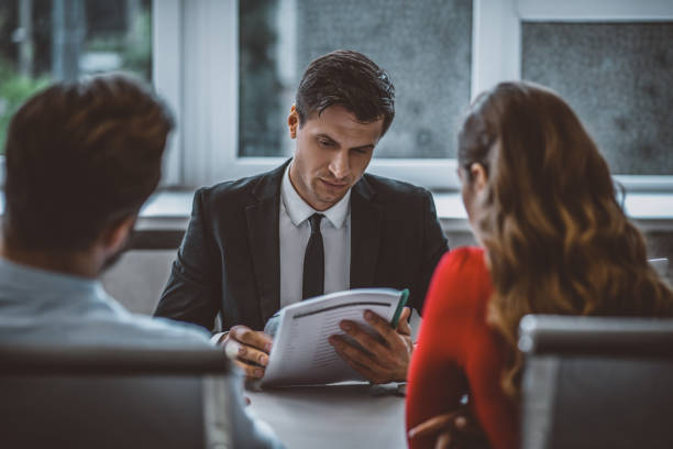 man and woman sitting at the lawyers office - divorce imagens e fotografias de stock