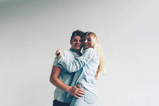 istock A pair of lovers cuddling near a white wall. 1252442753