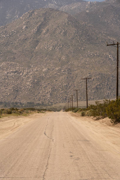 istock Empty, dusty road in the middle of nowhere 1252445127
